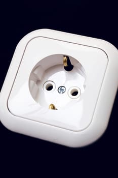 White electrical socket on a blue background close up