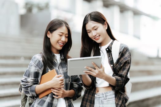 Young Asian woman college student with friends at outdoors. College student working on the college campus, education, school, study.