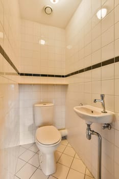 a bathroom with black and white tiles on the walls, toilet bowl and sink are in front of the mirror