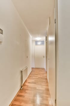 an empty room with wood flooring and white walls on either side, there is a heater in the corner