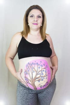 Pregnant woman with drawing on her belly. No copy space