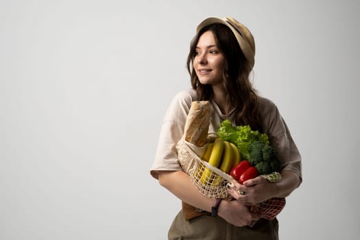 Portrait of young woman with a eco bag of vegetables, greens. Sustainable lifestyle. Eco friendly concept