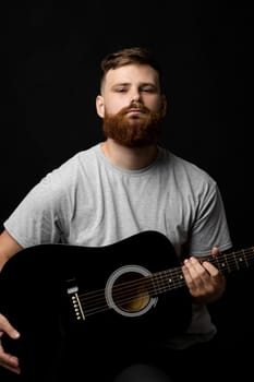 Portraite of handsome stylish bearded men with a acoustic guitar on a white background. Music performer musician. Musical string instrument