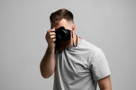 Professional bearded photographer holding a camera and ready to do a picture