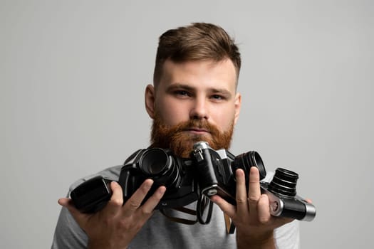 Close up portrait of man holding a old vintage film cameras