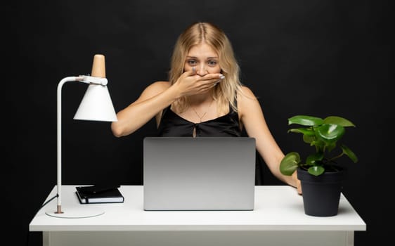 Frustrated, sad, stressed or depressed woman working with a laptop on a black background
