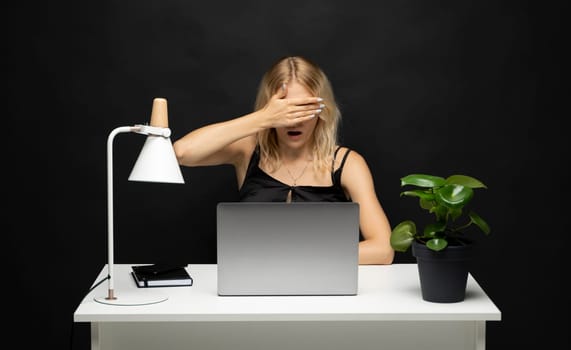 Frustrated, sad, stressed or depressed woman feeling tired while working with a laptop on a black background