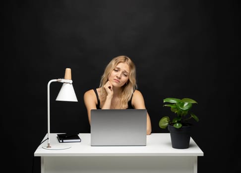 Frustrated, sad, stressed or depressed woman feeling tired while working with a laptop on a black background