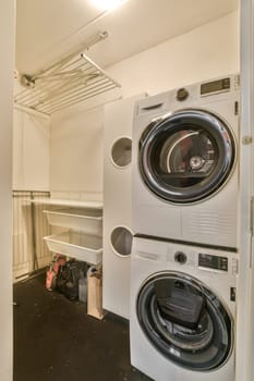 a laundry room with two washers and a dryer on the floor, in front of an open door