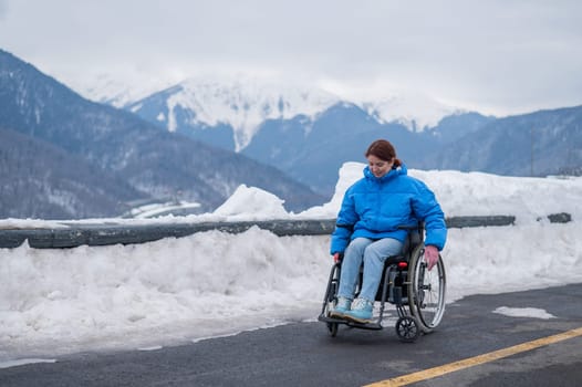 A woman in a wheelchair on a point view admires the high mountains. Thrust to life