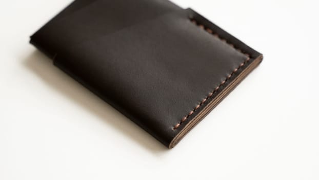 Brown empty men's business handmade genuine leather card holder with isolated on white background. Selective focus, copy space, close up