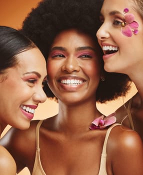 Women, beauty and flowers, makeup and diversity of models on orange studio background. Skincare, face and happy, young and elegant female group posing together with cosmetics, orchids or pink plants