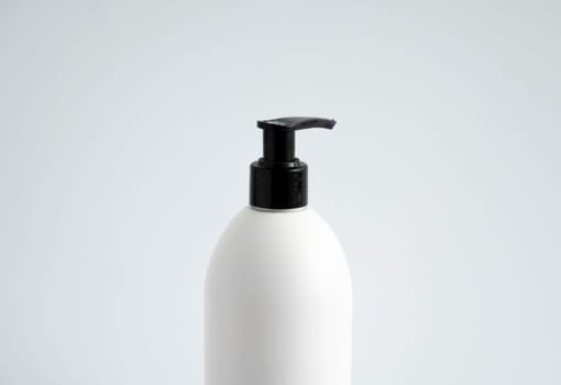 White unbranded bottle with a black dispenser isolated on white background. cosmetic packaging mockup with copy space. Bottle for a shower, gel, soap