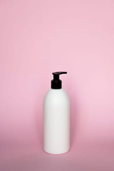 White unbranded plastic dispenser pump bottle on pink background. Cosmetic package mockup, liquid soap flacon, hand sanitizer without label, shampoo organic spa, shower gel