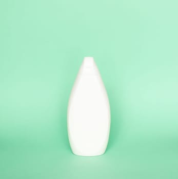 Blank shampoo bottle or shower gel on pastel green background. Container, beauty product and body care cosmetics