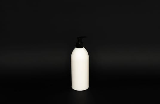 White unbranded bottle with a black dispenser isolated on black background. cosmetic packaging mockup with copy space. Bottle for a shower, gel, soap