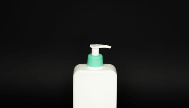 White bottle with a dispenser for liquid soap, shampoo, gel on black background