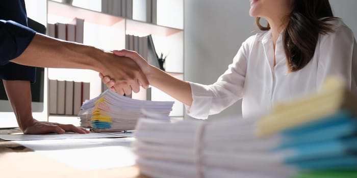 The business people shake hands after the meeting was successful and agreed upon.