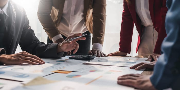 Business People Meeting using laptop computer,calculator,notebook,stock market chart paper for analysis Plans to improve quality next month. Conference Discussion Corporate Concept....