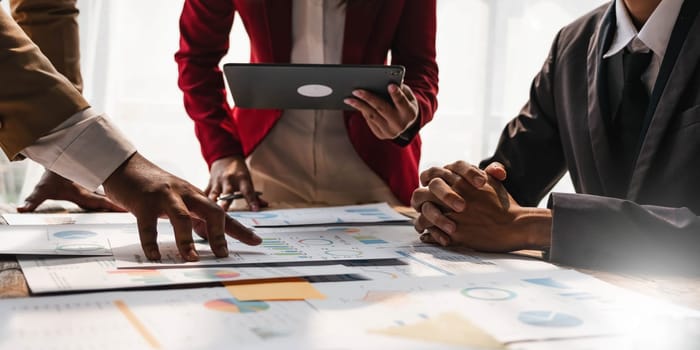 Business People Meeting using laptop computer,calculator,notebook,stock market chart paper for analysis Plans to improve quality next month. Conference Discussion Corporate Concept....