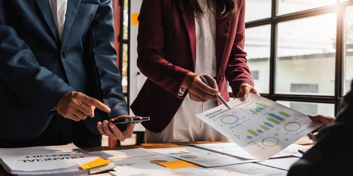 Business People Meeting using laptop computer,calculator,notebook,stock market chart paper for analysis Plans to improve quality next month. Conference Discussion Corporate Concept....