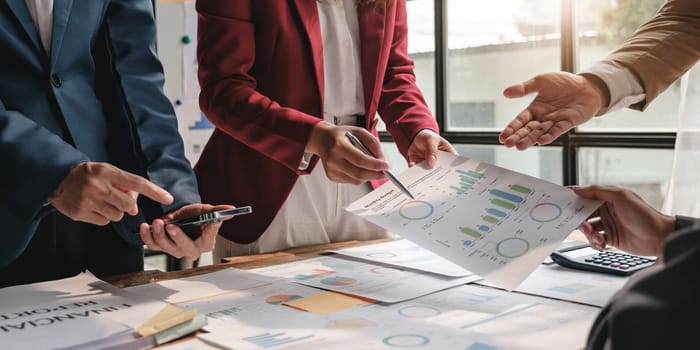 Business People Meeting using laptop computer,calculator,notebook,stock market chart paper for analysis Plans to improve quality next month. Conference Discussion Corporate Concept....