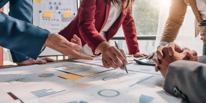 Business People Meeting using laptop computer,calculator,notebook,stock market chart paper for analysis Plans to improve quality next month. Conference Discussion Corporate Concept....