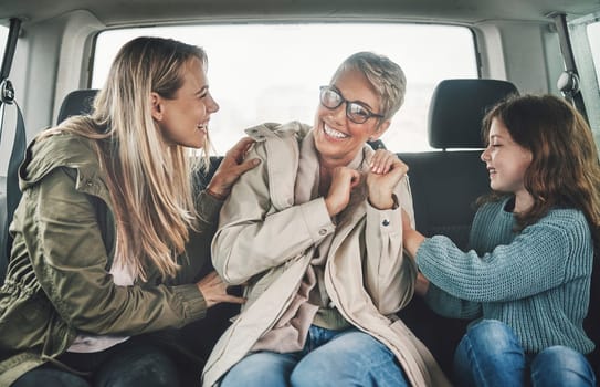 Playful, mother and children on a road trip in a car for travel, adventure and holiday together. Grandmother, mom and girl kid playing, bonding and happy with a smile on vacation with transportation.