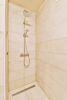 a shower with white tiles on the walls and floor in a small bathroom area that is clean and ready for guests to use