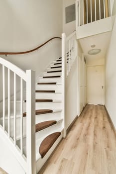 an empty room with wood flooring and white railings on the staircase leading up to the second floor in this house