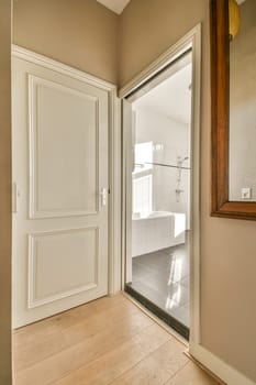 a white door in a room with light wood flooring and tile on the walls, there is a mirror hanging above it