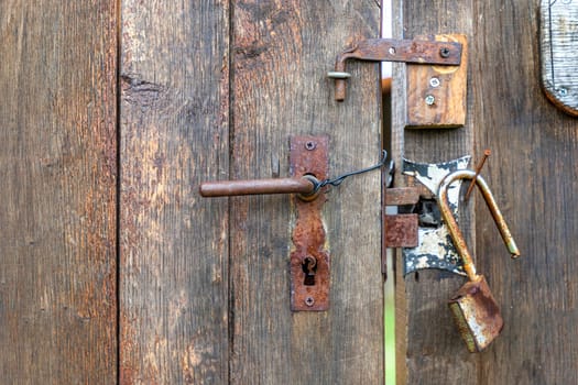 Different old metal locks of a wooden door. Close up