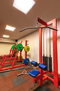 A part of the room with gym equipment in the sports club. Vertical view