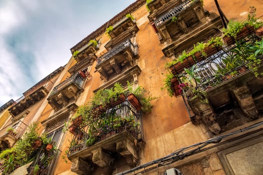 Vintage house with many Balconies with flowers in the City of Catania, Italy.