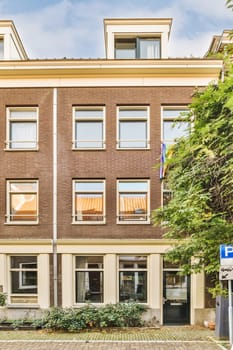 an apartment building in amsterdam, with the front door open and trees growing on either side of the street - stock photo