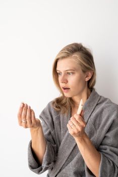 Womens health. Spa and wellness. Young woman in gray bathrobes suffering from hairloss. Focus on the foreground