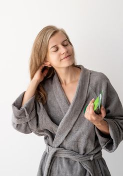 Womens health. Spa and wellness. Happy young woman applying hair mask in bathroom