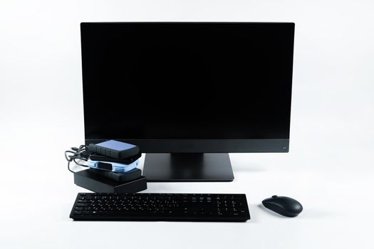 Multiple external hard drives connected to a monoblock on a white background.Computer with hard drive.