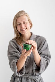 Womens health. Spa and wellness. Young smiling woman holding bottle with beauty product