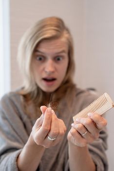 Womens health. Spa and wellness. Young woman in gray bathrobes suffering from hairloss