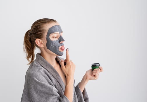 Womens health. Spa and wellness. Happy funny woman applying face mask and tasting it