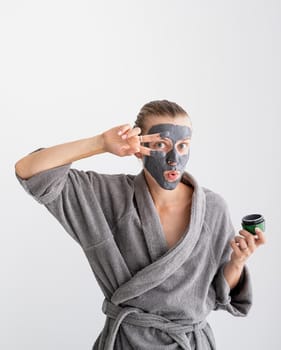 Womens health. Spa and wellness. Happy funny woman applying face mask waving hello