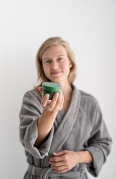 Womens health. Spa and wellness. Young smiling woman holding bottle with beauty product