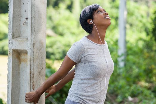 Sports and hobbies. Sporty smiling woman doing outdoor stretching in the park. Woman exercising in fresh air.