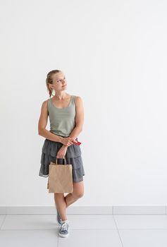 Online shopping concept. Young smiling woman holding eco friendly shopping bags and creadit card