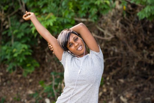 Female training at the park. Young woman warms up and stretches her arms outdoors in the morning. Healthcare, sport and exercise concept