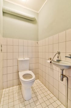 a bathroom with white tiles and a toilet in the corner next to it is a sink, fauced on the wall