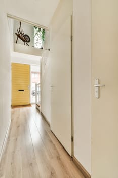 the inside of a house with wood floors and white walls, an open door leading to a bright yellow front door