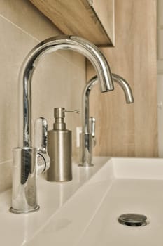 a bathroom sink with soap dispenser and toothbrushs on the counter in front of the sink