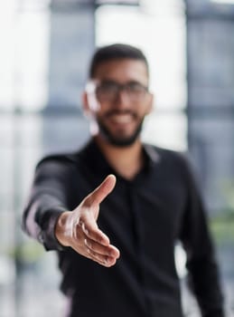 smiling businessman reaching out for a handshake